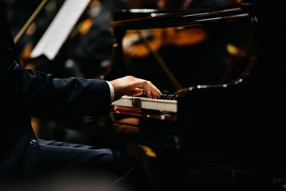 A person playing piano in front of a crowd.