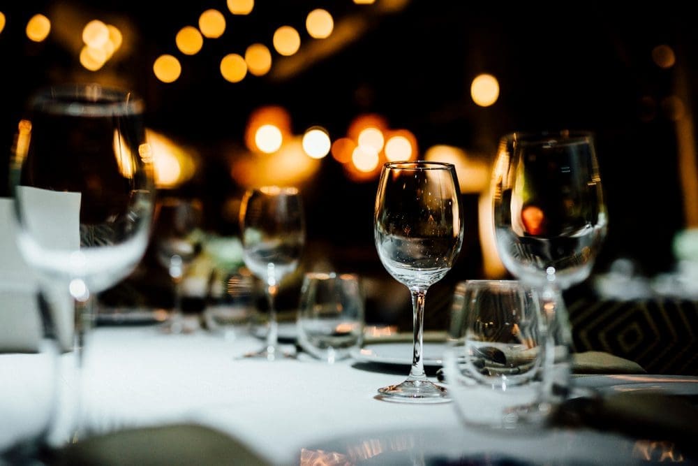 A table with wine glasses and plates on it