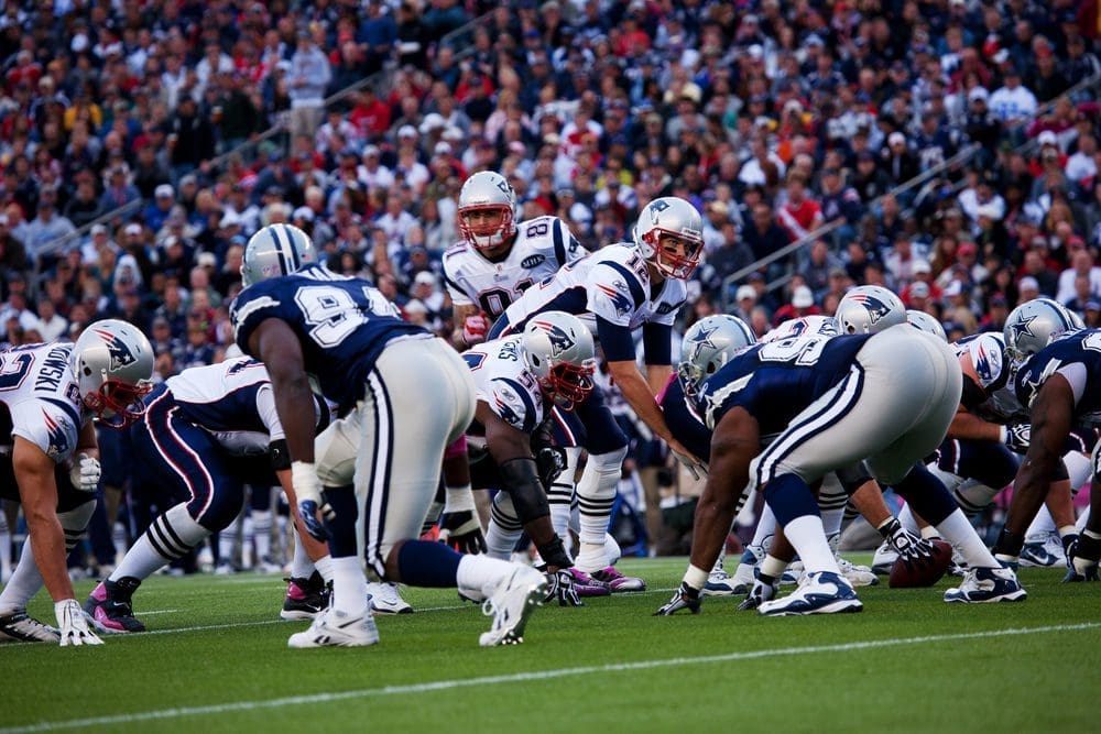 A group of football players are playing on the field.