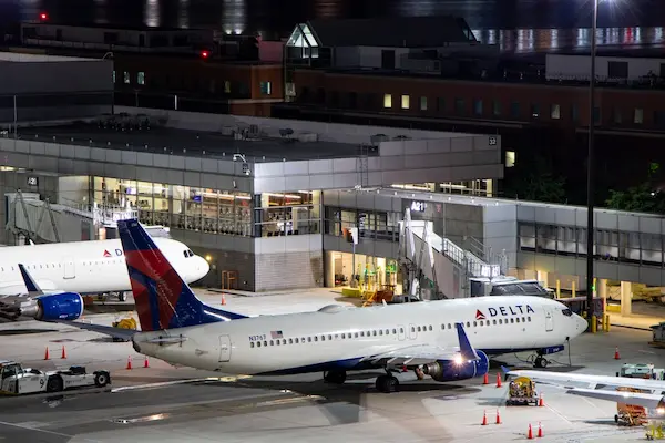 Delta airplane parked at Boston Logan Airport at night, viewed from above