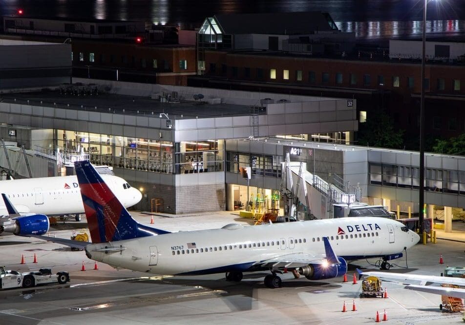 A delta airplane is parked at an airport.